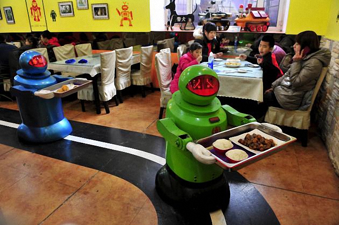 Robots deliver dishes to customers at a Robot Restaurant in Harbin, Heilongjiang province in this January 12, 2013 file photo. Three-fourths of robot installations over the next decade are expected to be concentrated in four areas: transportation equipment, including the automotive sector; computer and electronic products; electrical equipment and machinery. Labor costs have climbed in countries such as China that have been popular for outsourcing production, while technological advances for robots allow them to be more flexible and perform more tasks. REUTERS/Sheng Li/Files  ATTENTION EDITORS - THIS PICTURE IS PART OF THE PACKAGE "RISE OF THE MACHINES". TO FIND ALL 20 IMAGES SEARCH 'TECHNOLOGY ROBOTS'.